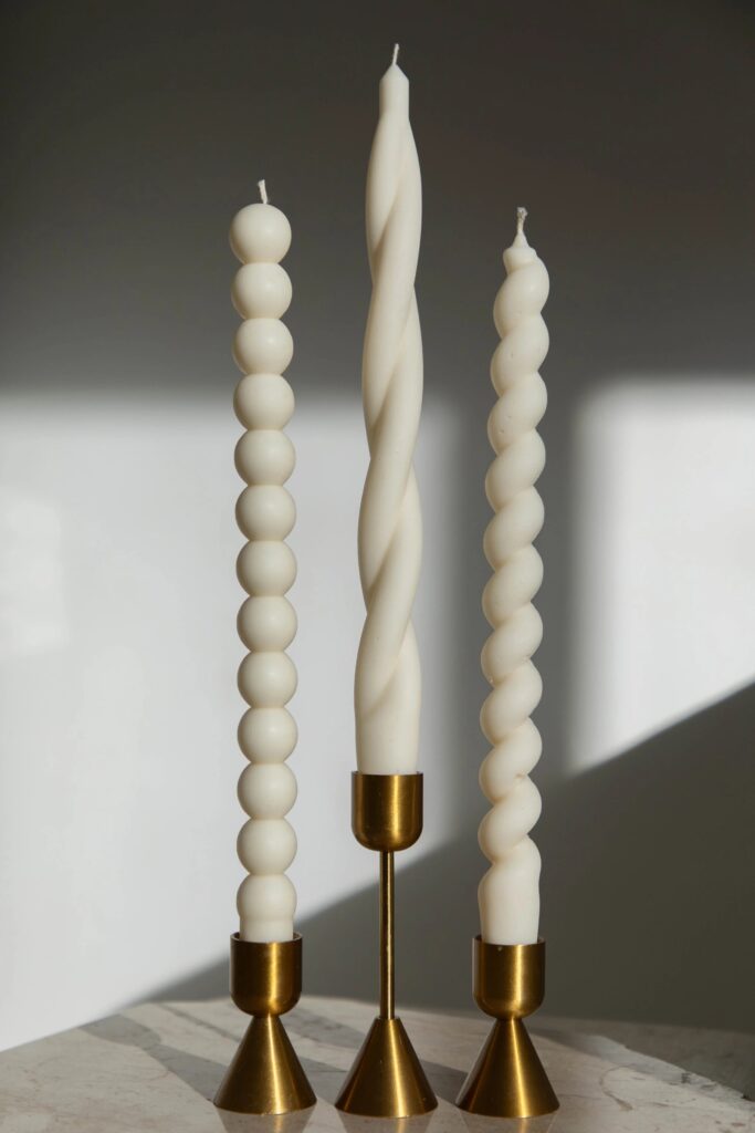 Twisted and bubble taper candles in brass holders