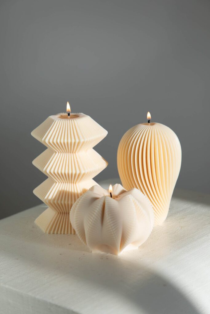 Ivory zigzag, ribbed and flower candles, lit